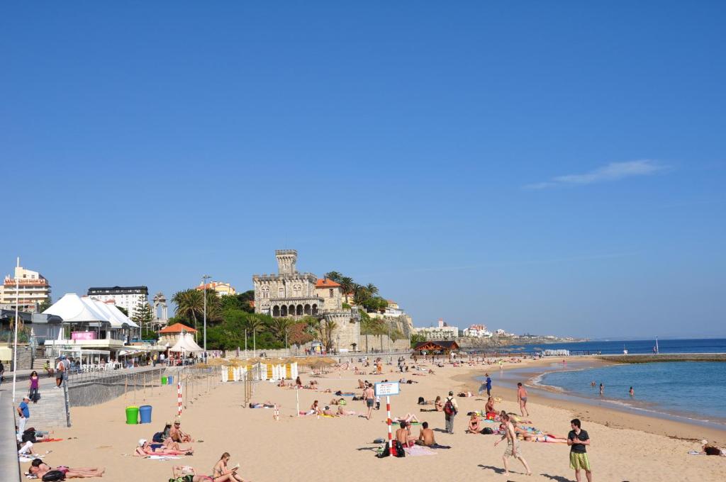 a group of people on a beach near the ocean at Somewhere - Estoril Guesthouse in Estoril