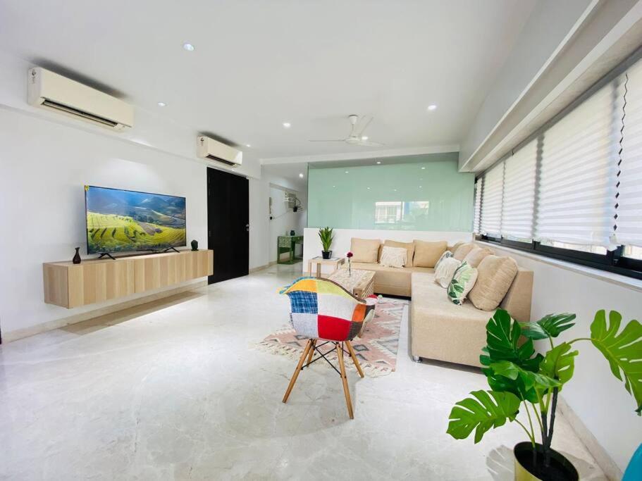 a living room with a couch and a tv at Kakad Classic 5, 16th Rd, Pali Village, Khar West by Connekt Homes in Mumbai
