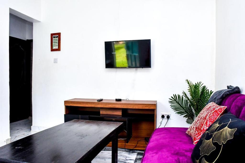 salon z kanapą i telewizorem na ścianie w obiekcie Davis Homes w Kitale