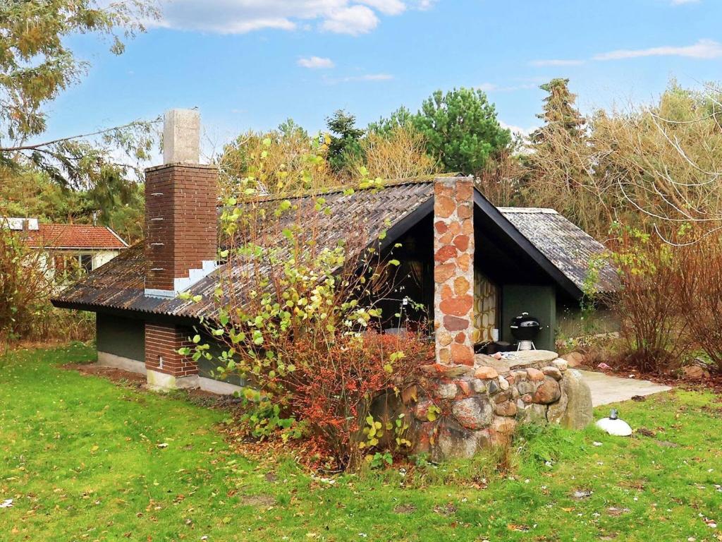 an old brick house with a chimney in a yard at Three-Bedroom Holiday home in Rødby 28 in Kramnitse
