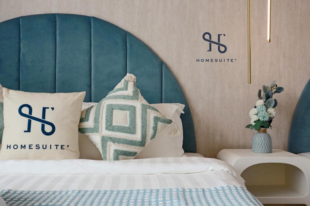una camera da letto con letto con testiera e cuscini blu di Homesuite' Home at Aeropod SOVO a Kota Kinabalu
