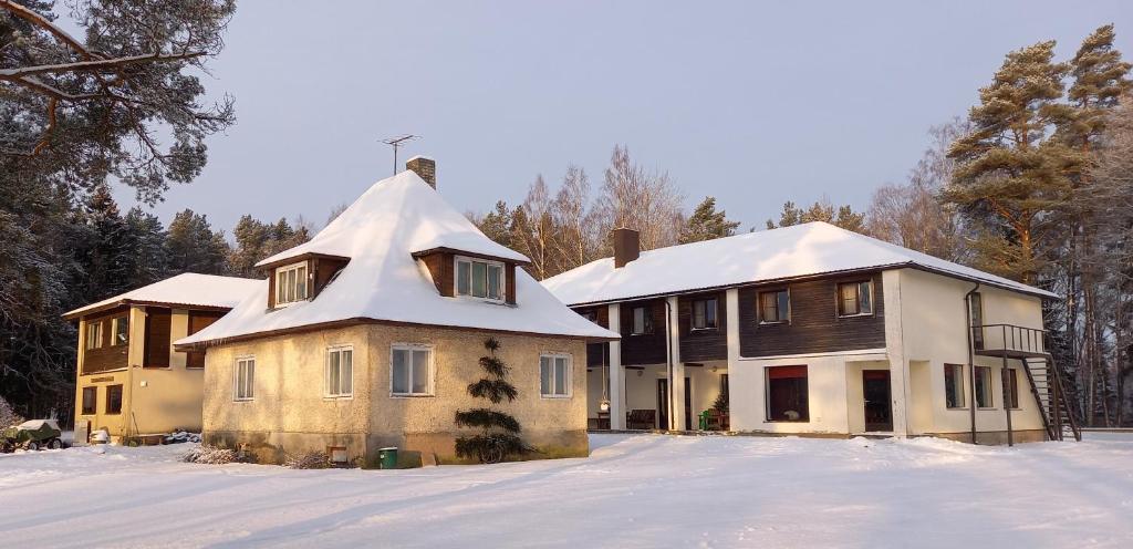 ein Haus mit schneebedecktem Dach im Schnee in der Unterkunft Veldemani puhkemaja in Vaibla