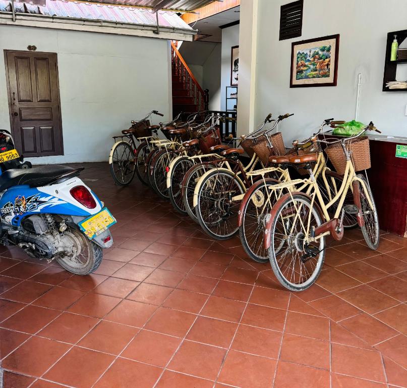 uma fila de bicicletas estacionadas ao lado de uma parede em Singrarat Hotel em Luang Prabang