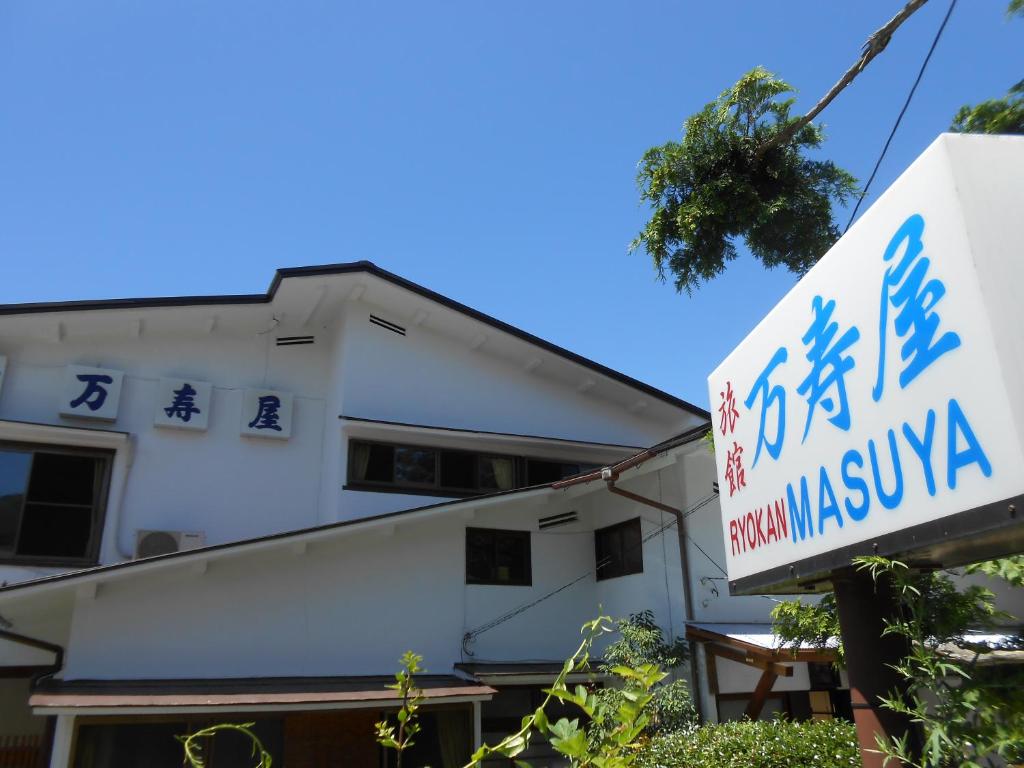 een gebouw met een bord ervoor bij Ryokan Masuya in Hakone