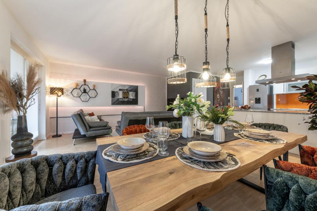 a dining room and living room with a table and chairs at Alpenflair / Luxury / 100qm / Work / Travel / Netflix in Penzberg