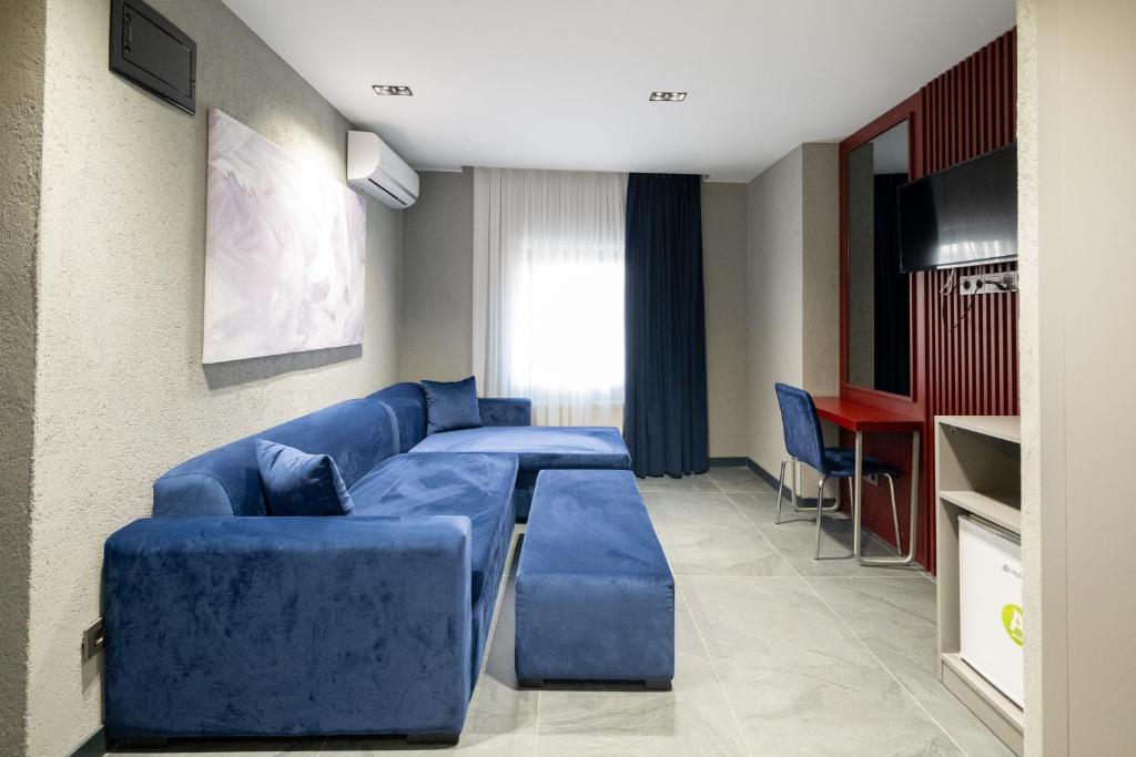 een woonkamer met een blauwe bank en een tafel bij Voir Hotel Pera in Istanbul