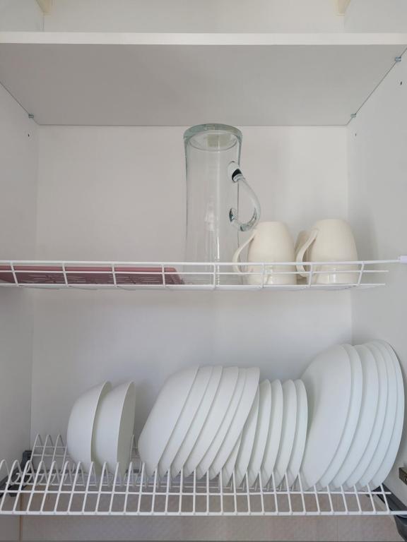 a row of plates and eggs on a shelf in a refrigerator at Maironio apartamentai in Radviliškis