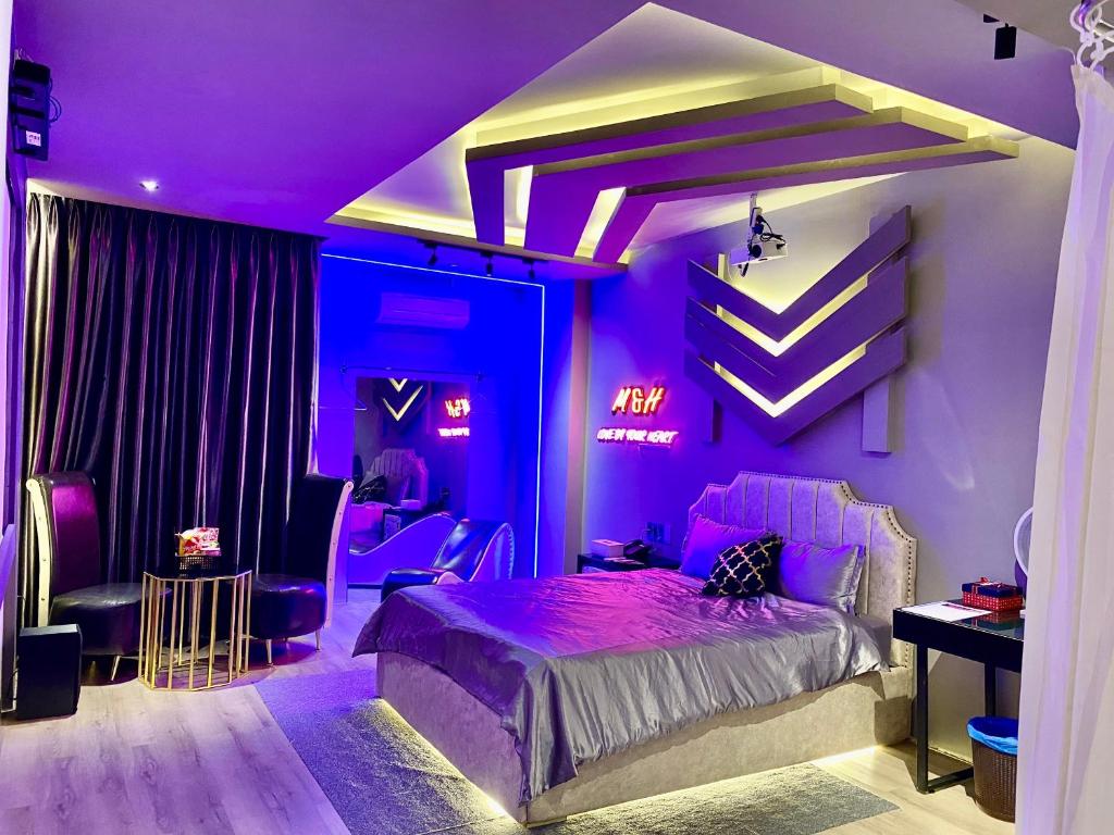 a purple bedroom with a bed and a desk at M&H Cinema in Ho Chi Minh City