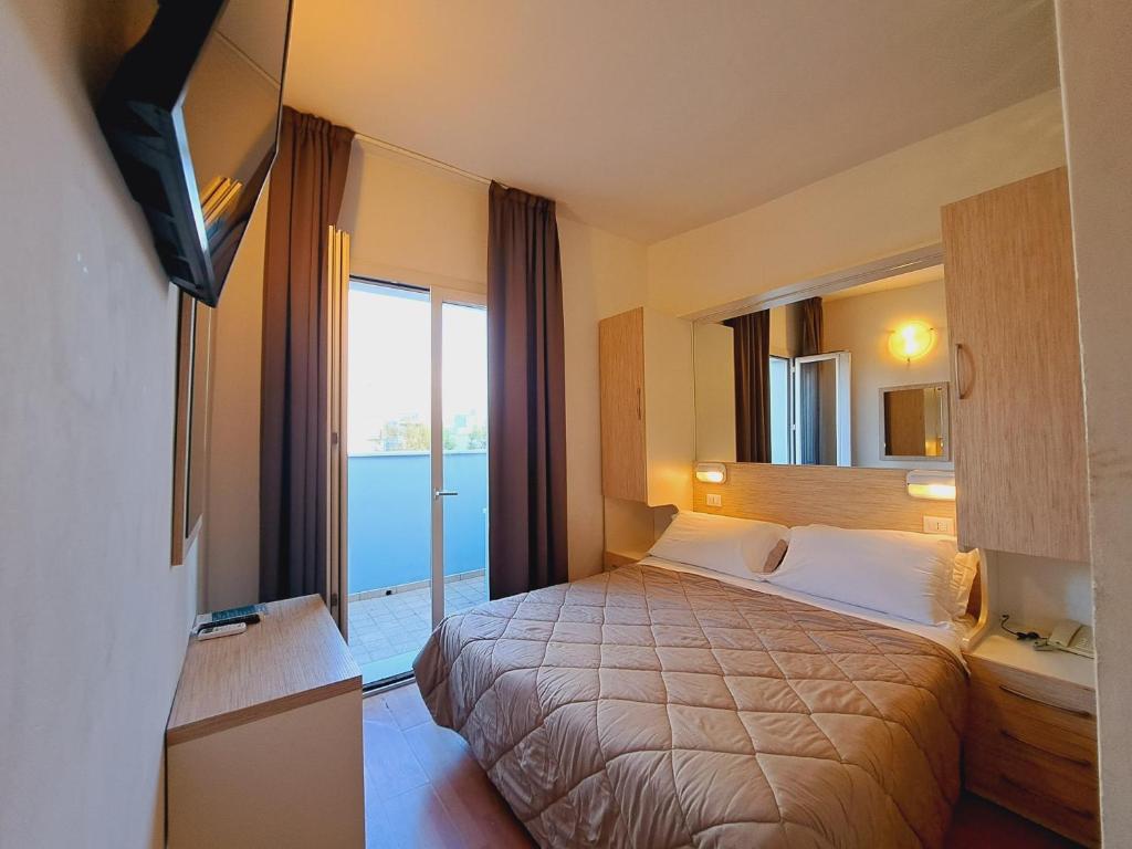 una camera d'albergo con letto e TV di Hotel Butterfly a Rimini