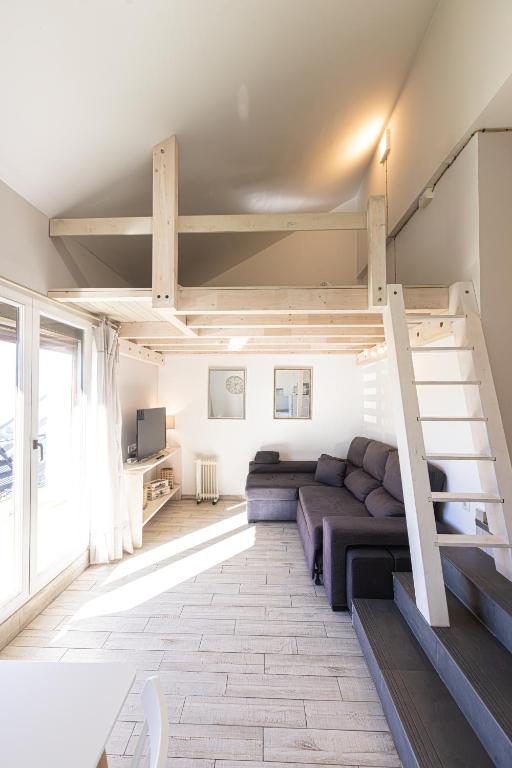a living room with a couch and a loft bed at LUZ in Sierra Nevada