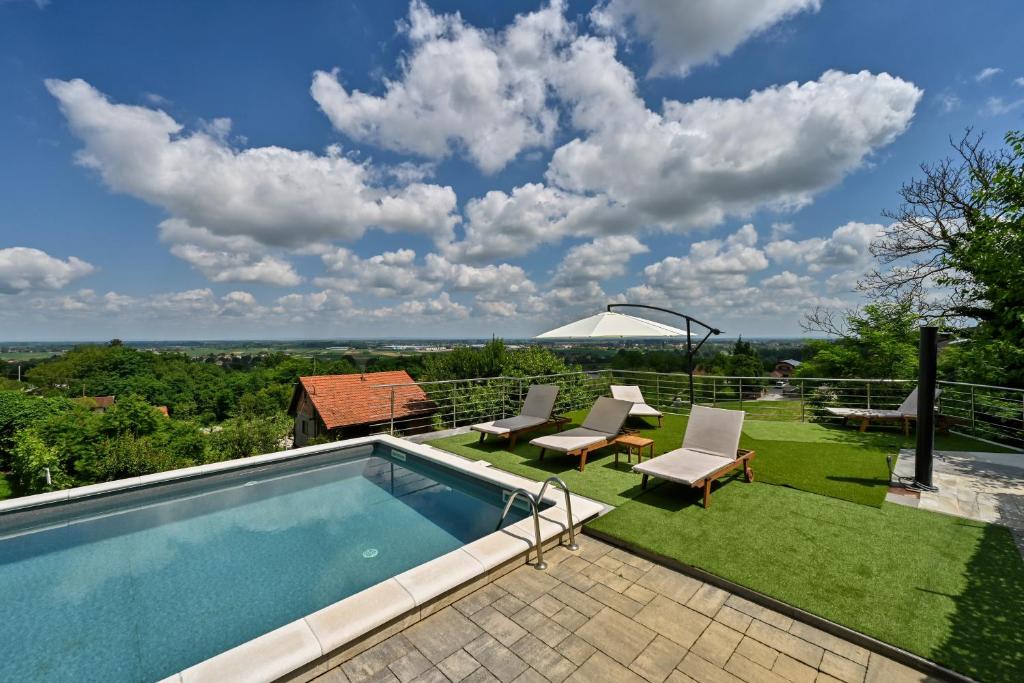 a swimming pool with two chairs and a table at Iva's Place in Ludbreg