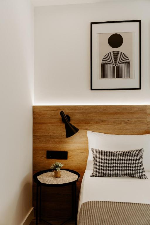 a bedroom with a bed with a table and a picture at Apartamento Plaza Logroño y Aire Acondicionado in Logroño