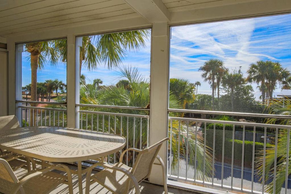 a porch with a table and chairs and a view of the ocean at Seaside Therapy~ in Seabrook Island