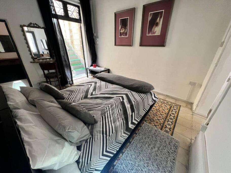 - une chambre avec un lit doté d'oreillers et d'une fenêtre dans l'établissement Graswald, 1 bedroom accommodation, à Il-Gżira