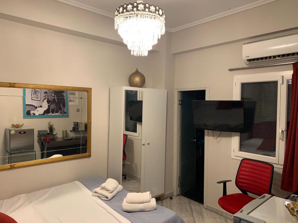 a room with a bed and a mirror and a tv at Alexander Luxury House in Athens