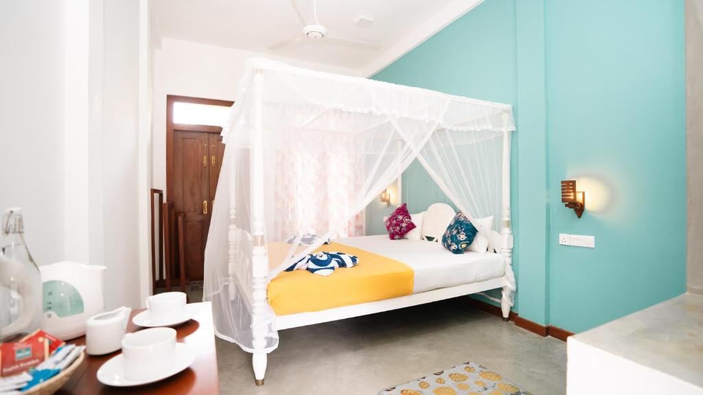 a bedroom with a bed with a canopy at Daffodil Restaurant & Holiday Resort in Unawatuna