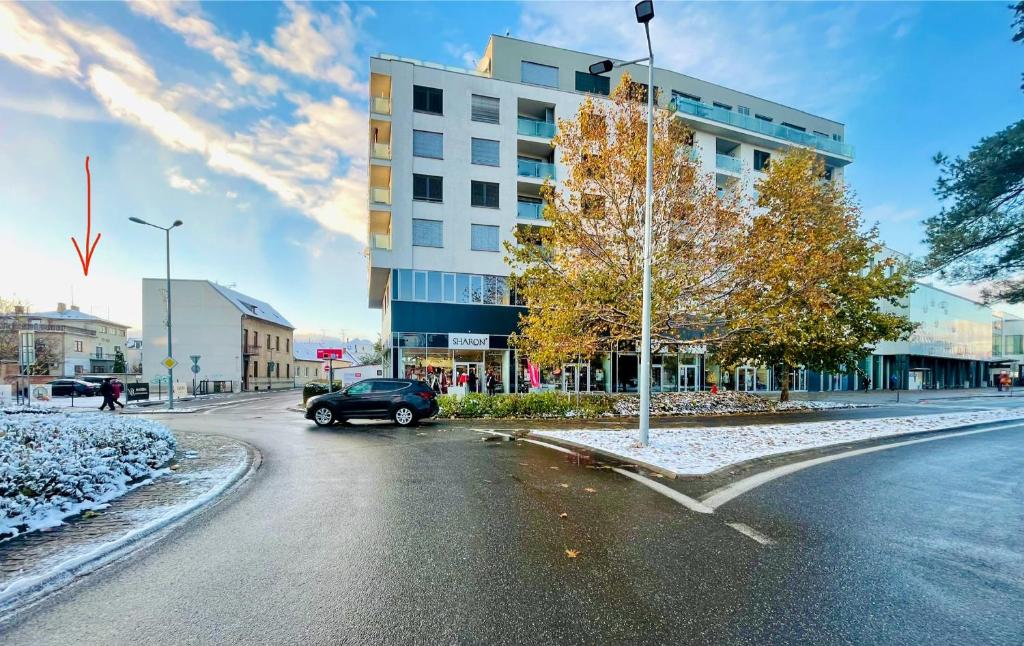 um carro a descer uma rua em frente a um edifício em Krásný apartmán v centru Piešťan em Piešťany