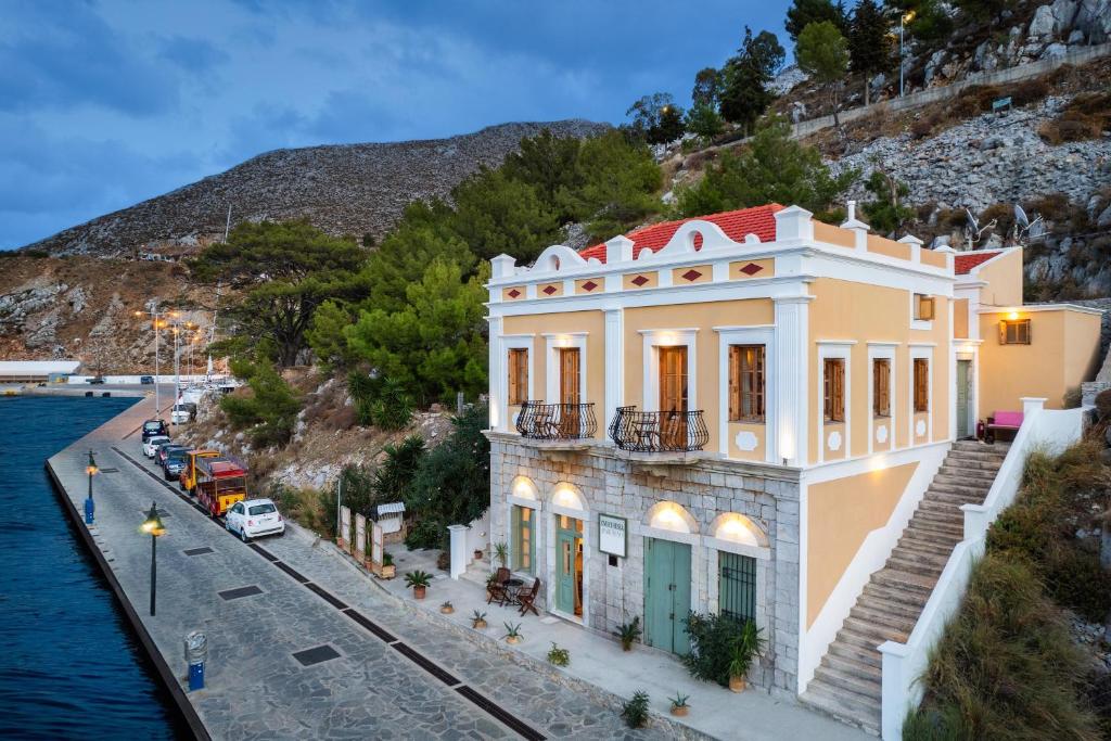 a building on the side of a street next to the water at Over The Sea Apartments in Symi