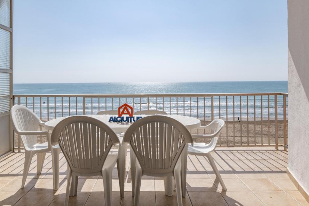 einen Tisch und Stühle auf einem Balkon mit Strandblick in der Unterkunft Santa Marta, I- A 4º-11 in Cullera