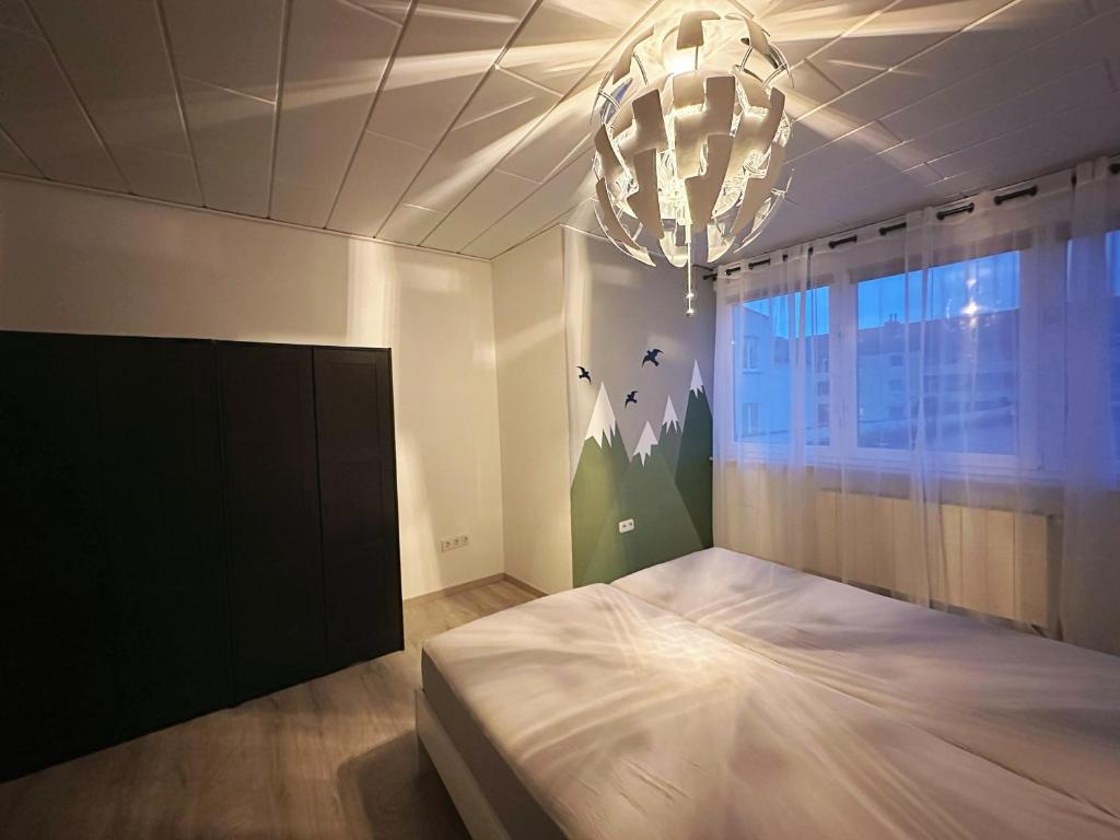 sypialnia z dużym łóżkiem i żyrandolem w obiekcie Zimmer in 100m² Wohnung mit Terrasse w mieście Duisburg