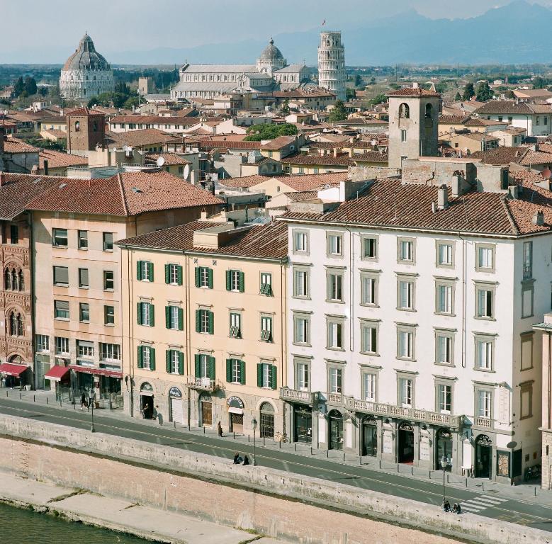 ein großes weißes Gebäude neben einer Stadt in der Unterkunft Royal Victoria Hotel in Pisa