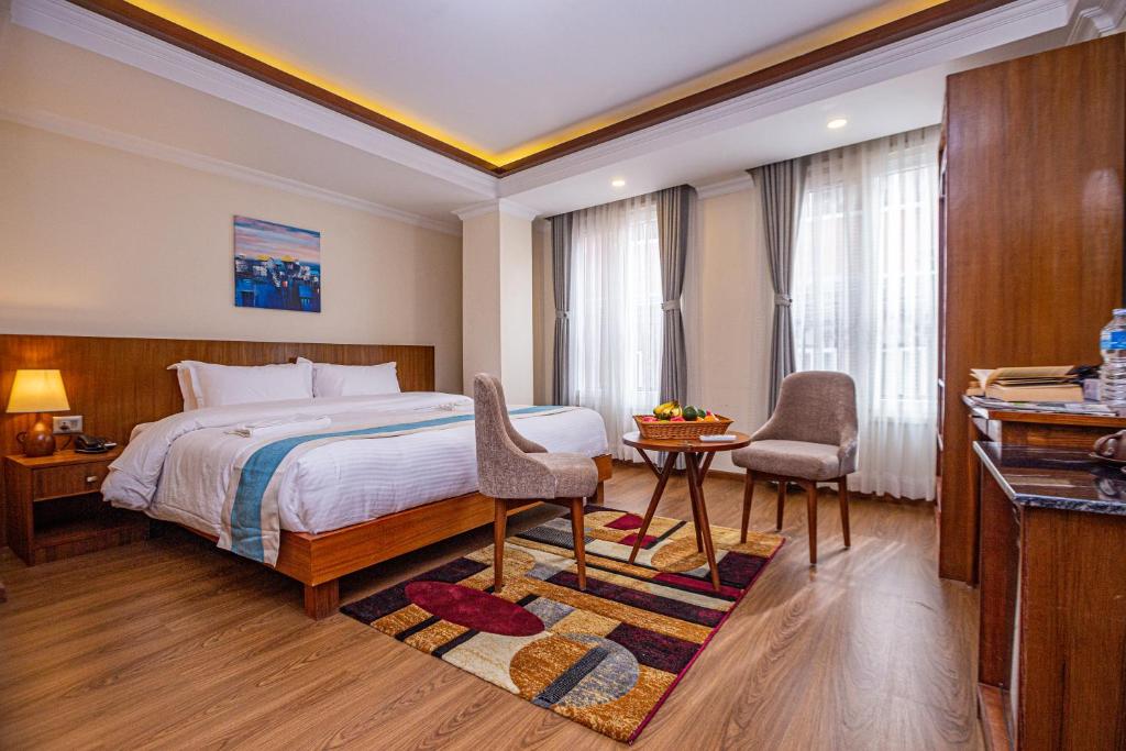 Darbar Heritage Inn في كاتماندو: غرفة فندقية بسرير وطاولة وكراسي