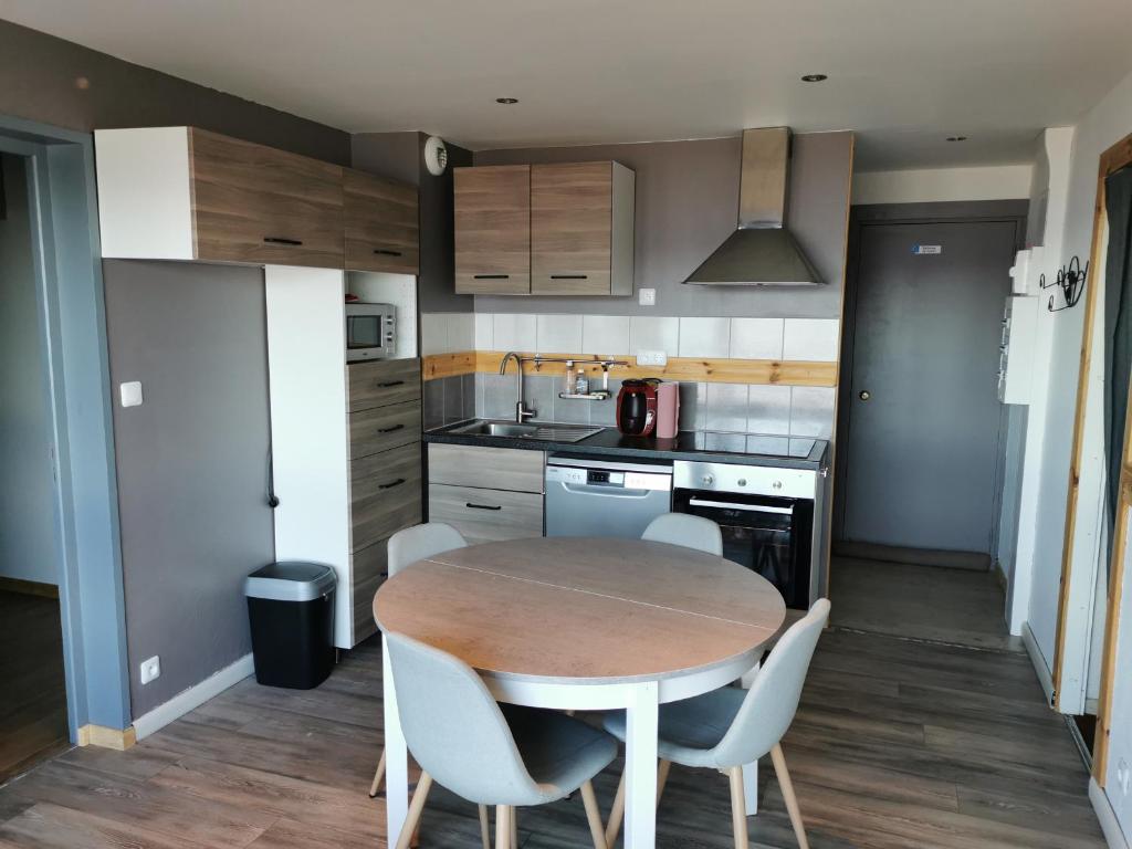 a kitchen with a wooden table and white chairs at Appartement Les Adrets-Prapoutel, 3 pièces, 6 personnes - FR-1-771-56 in Les Adrets