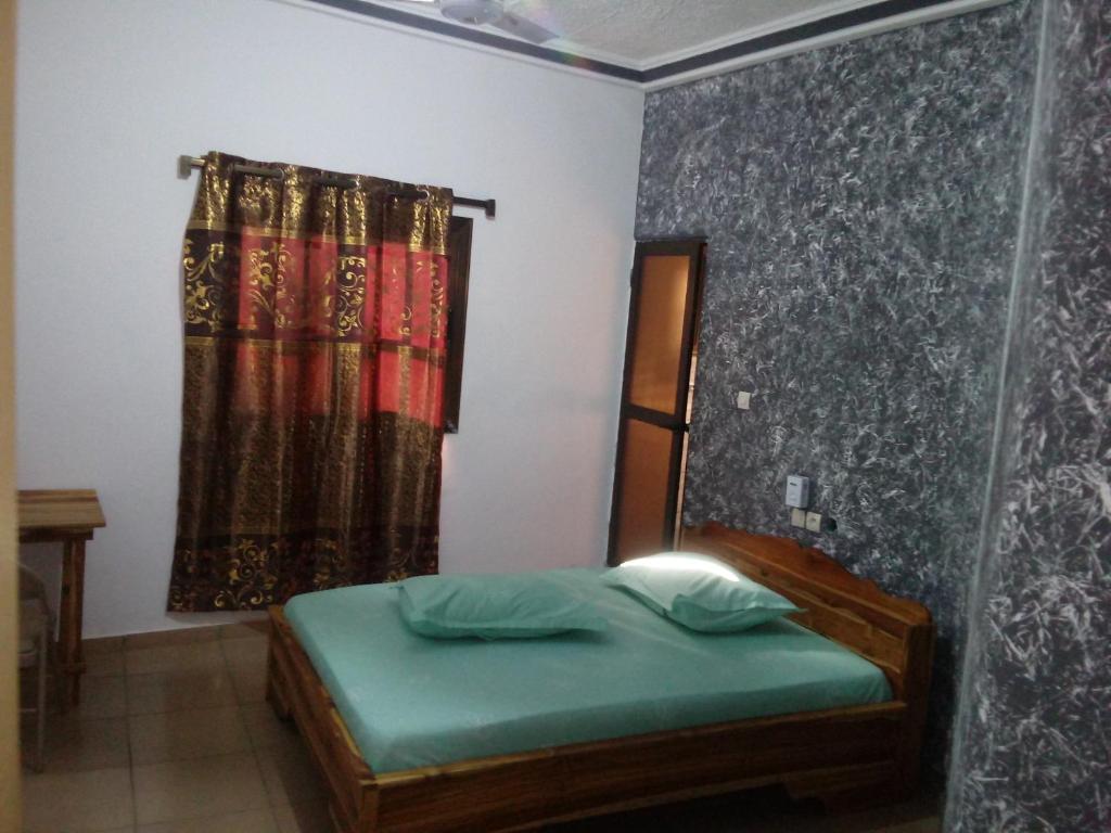 um quarto com uma cama e uma janela com uma cortina em Hotel TK d'Or 