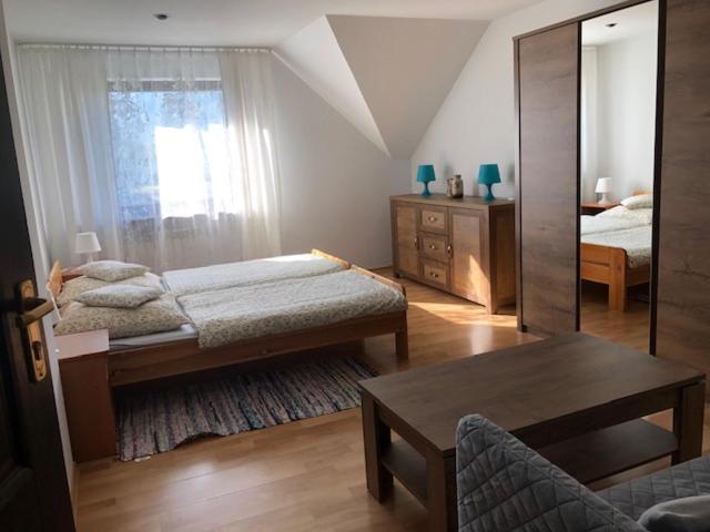 a bedroom with a bed and a mirror and a table at BUKOLIKA in Rajcza