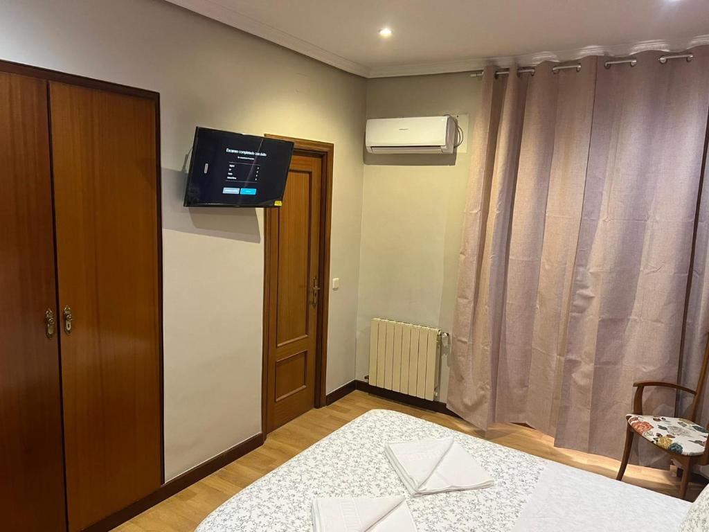 um quarto com uma cama e uma televisão na parede em Hostal New Dream Madrid em Madri