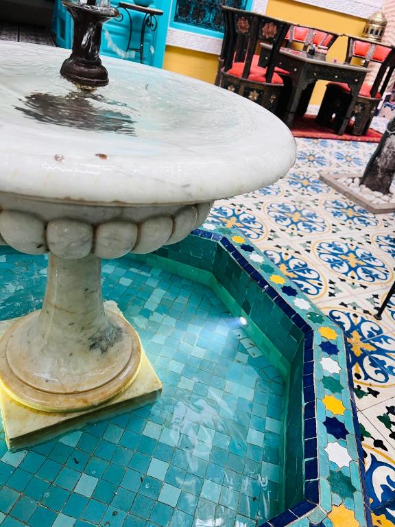 a fountain sitting on top of a tile floor at Riad Al Nour in Marrakech