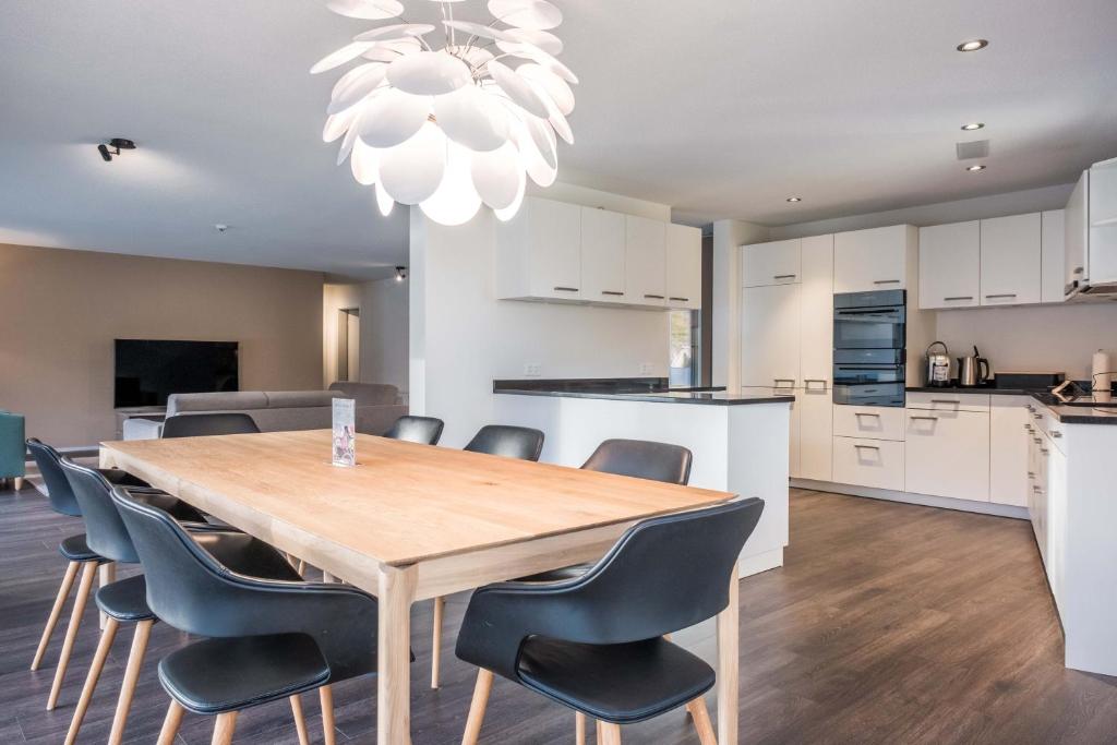 eine Küche und ein Esszimmer mit einem Holztisch und Stühlen in der Unterkunft Apartment Alpeglöggli - GriwaRent AG in Interlaken