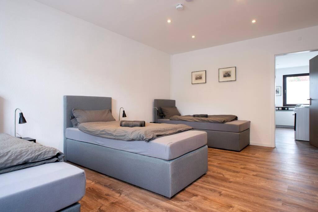Habitación blanca con 2 camas y suelo de madera. en Work & Stay Apartment Goch en Goch