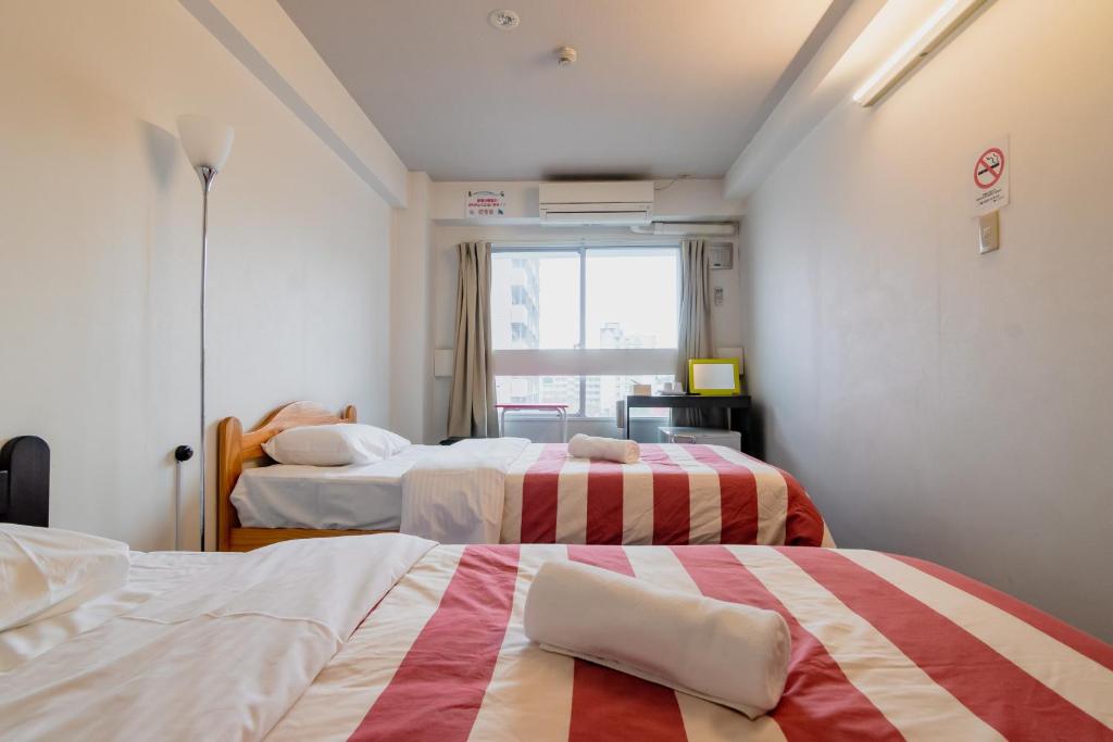 Postel nebo postele na pokoji v ubytování Fukuoka Share Hotel