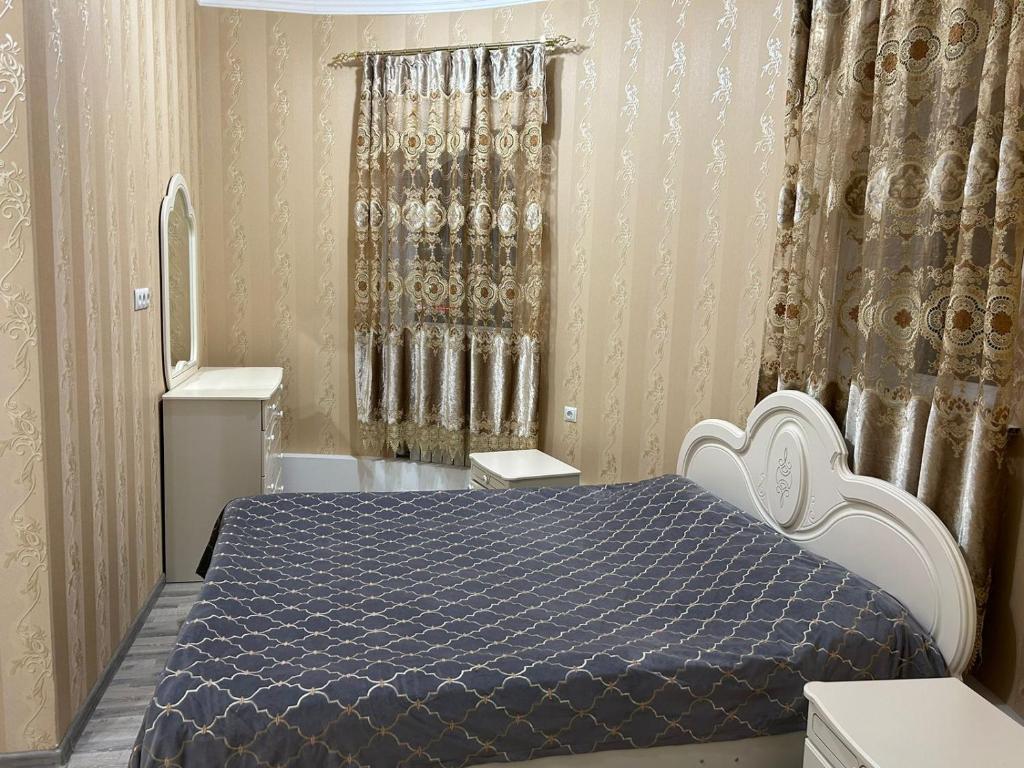 a bedroom with a bed with a blue comforter at Уютная квартира комфорт класса111 in Astana
