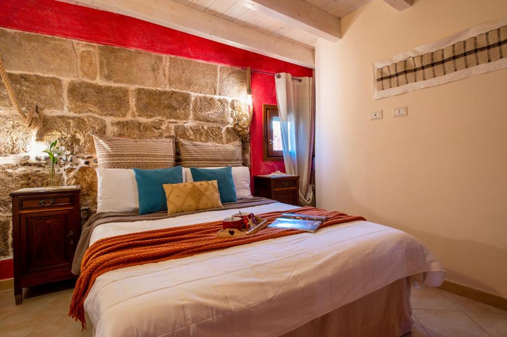 a bedroom with a large bed with a stone wall at La Casa di Zaira in Alghero