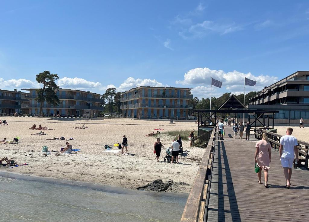 eine Gruppe von Menschen am Strand in der Nähe eines Piers in der Unterkunft ÅhusBrygga Apartment Hotel in Åhus