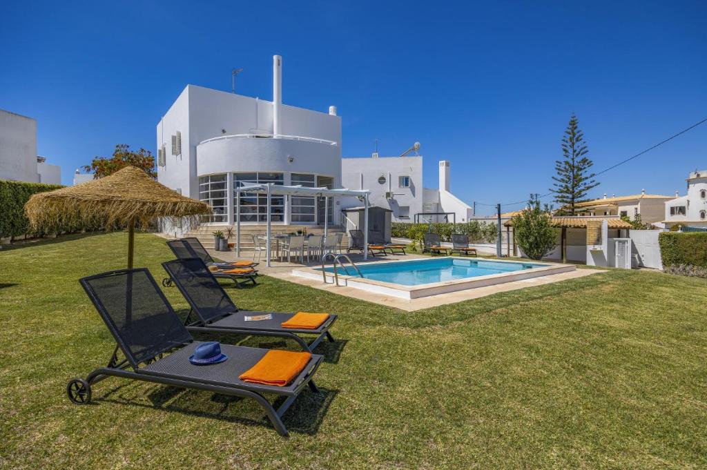 um quintal com duas cadeiras e uma piscina em Villa Casa Duarte by Villa Plus nos Olhos de Água