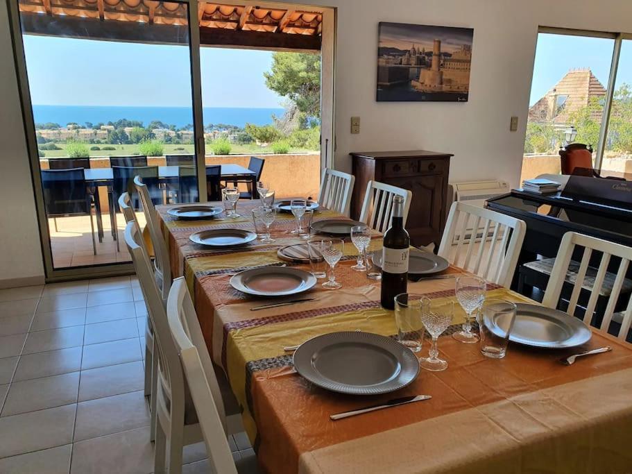 - une table à manger avec des assiettes et des verres dans l'établissement Villa Horizon/Vue mer/Plages/WIFI/CLIM, à Carqueiranne