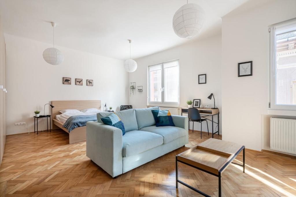 uma sala de estar com um sofá e uma cama em Liget Apartment em Budapeste