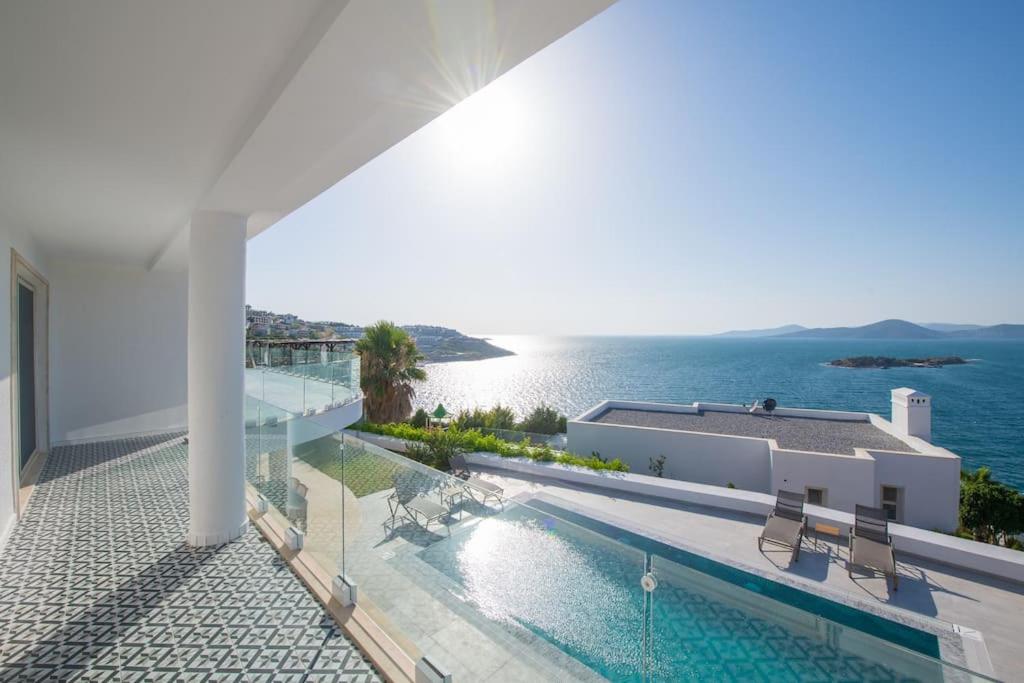 een wit huis met een zwembad en de oceaan bij BEACH FRONT SUPER VİLLA Boss 1 in Bodrum City