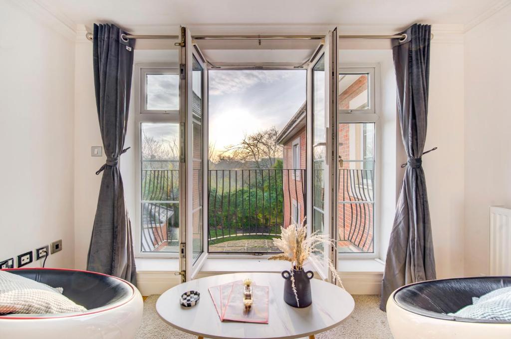 - un salon avec deux baignoires et une grande fenêtre dans l'établissement 3-Bedroom Penthouse, Brentford, Free Parking, à Brentford