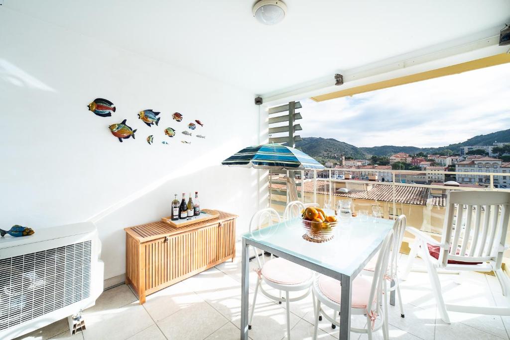 Un balcón con mesa y sillas y una vista en Le Nautilus - Charmant apt proche de la plage, en Port-Vendres