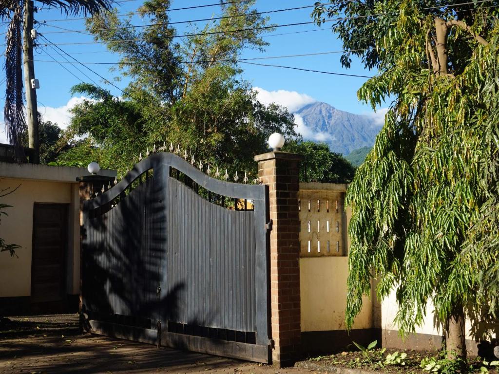 a gate to a house with a mountain in the background at Nareto House in Arusha