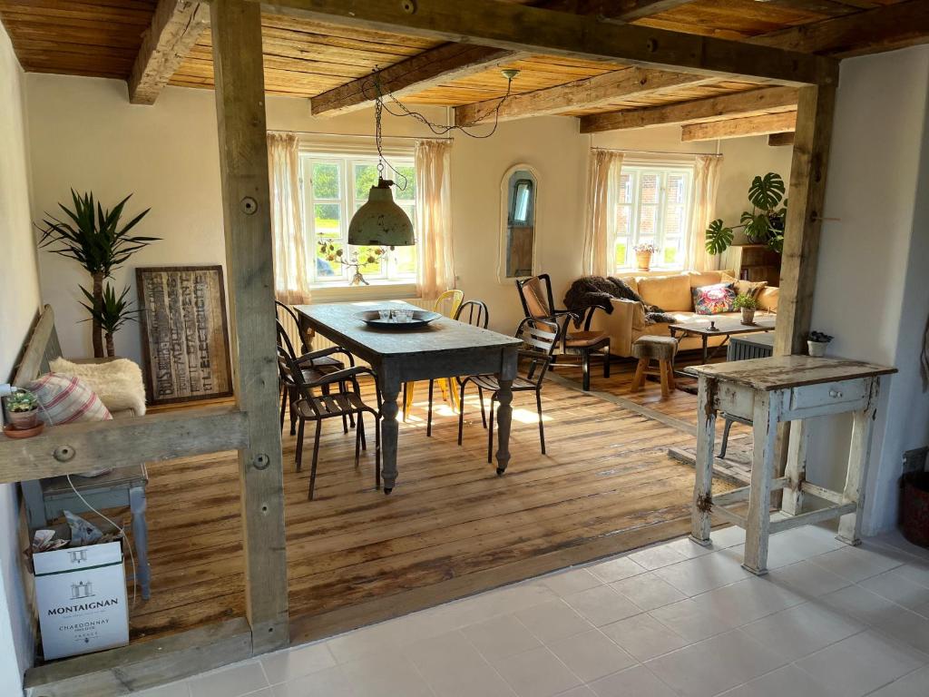 a dining room and living room with a table and chairs at The Beach Farm - charm, beach and stunning nature in Bedsted Thy