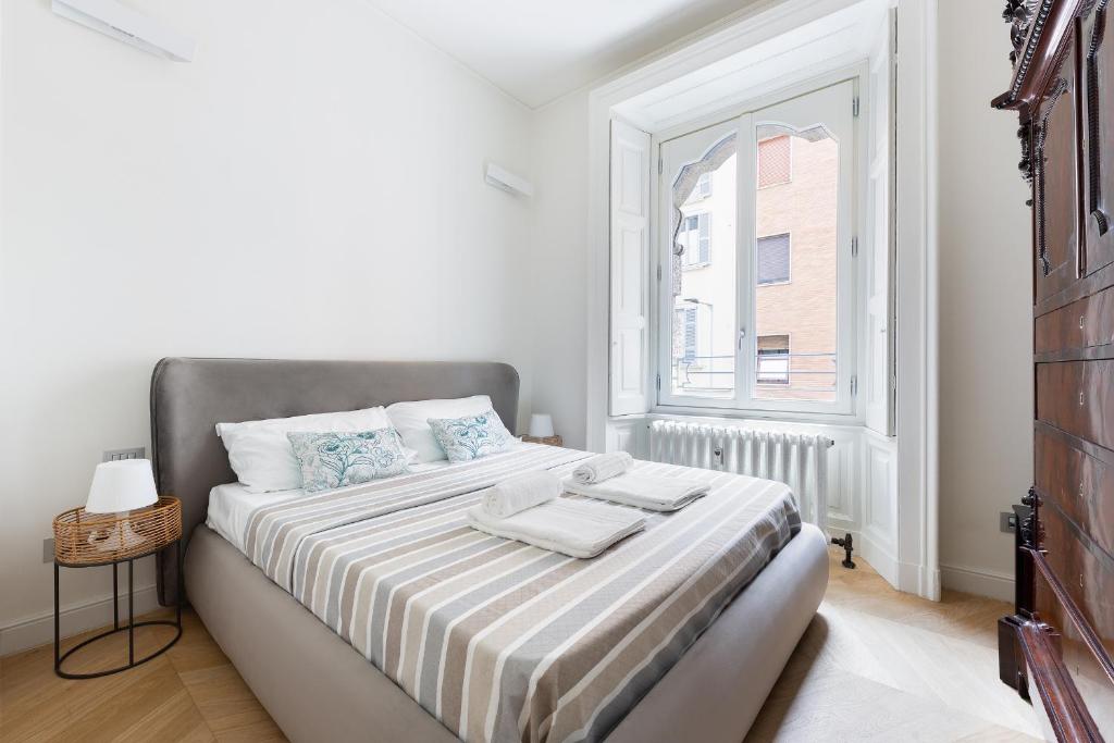 ein weißes Schlafzimmer mit einem Bett und einem Fenster in der Unterkunft HL Apartment - Sant'Ambrogio, Duomo in Mailand