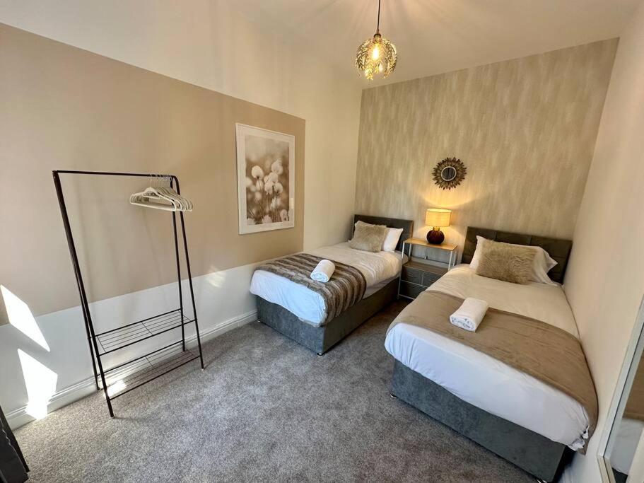 a hotel room with two beds and a lamp at Three bedroom home Manchester, sleeps 9! in Manchester