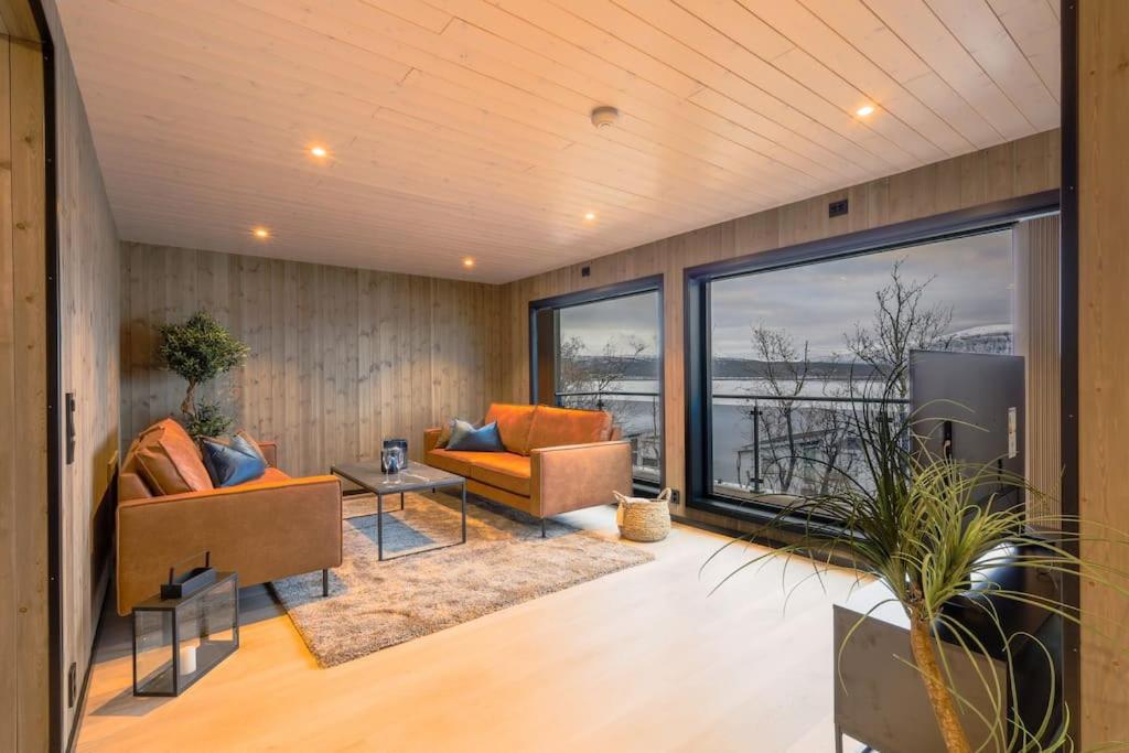 a living room with two couches and a large window at Luksus panorama hytte -H24 in Mestervik