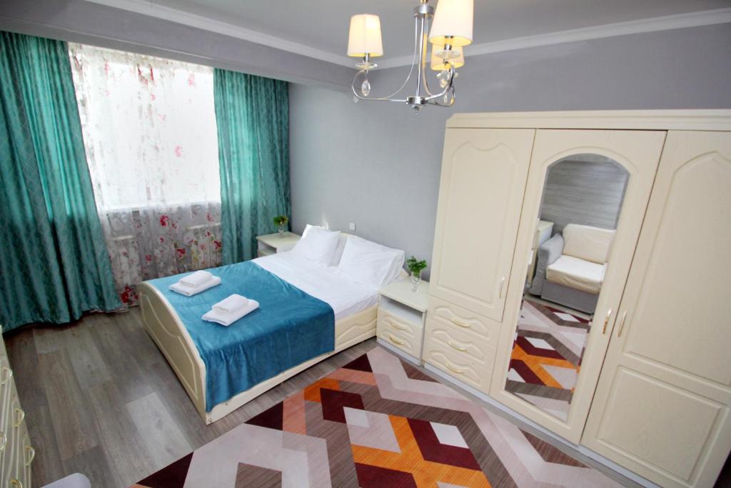 a small bedroom with a bed and a dresser at ЖК Айгерим in Almaty