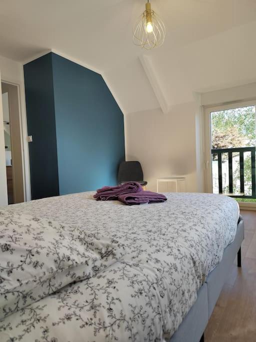 une chambre avec un lit et un mur bleu dans l'établissement Maison au coeur de ville parking, à Paimpol